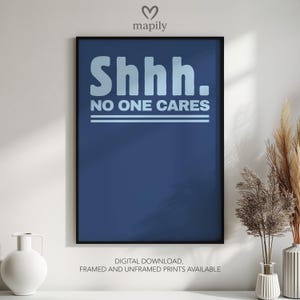 Op de afbeelding: Een ingelijste kunstdruk met een marineblauwe achtergrond en de witte woorden "Shhh. NO ONE CARES". De print is een digitale download, verkrijgbaar met of zonder lijst. Het kunstwerk wordt op een wit oppervlak weergegeven.