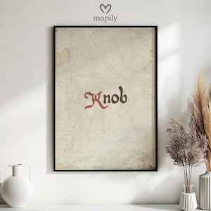 May include: Framed art print with the word "Knob" in a stylized, medieval-style font. The text is dark red. The background is vintage-style paper with brown stains. The print is in a black frame.