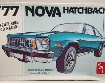 Puede incluir: Kit de modelo '77 Nova Hatchback con radio CB. La caja muestra un coche turquesa con detalles cromados. El kit es un kit de hobby sin montar.
