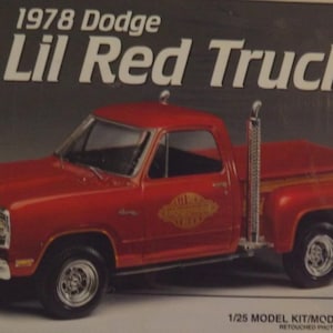 May include: A red 1978 Dodge Lil Red Truck model kit. The box art shows a detailed image of the truck with chrome accents, a wood-lined bed, and a prominent exhaust stack. The kit is skill level 2.