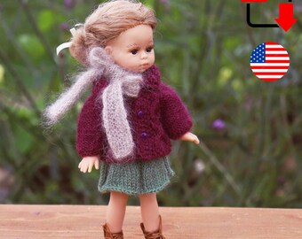 Könnte beinhalten: Eine Puppe in einer weinroten Strickjacke, einem grünen Rock und braunen Stiefeln. Die Puppe hat einen hellgrauen Schal und eine hellbraune Frisur. Das Bild enthält ein PDF-Symbol und ein US-Flaggen-Symbol.