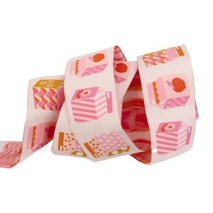 May include: Pink and orange ribbon with a repeating pattern of stylized juice boxes. The boxes have pink, orange, and white stripes and a small red apple on top.