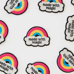 May include: A set of six iron-on patches featuring a rainbow with a cloud and the text "made with magic".