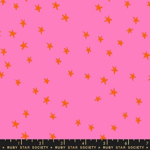 Puede incluir: Tela rosa con un patrón repetido de estrellas naranjas. La tela tiene una regla con marcas en pulgadas y el texto "RUBY STAR SOCIETY" impreso en ella.