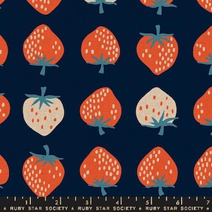 May include: A repeating pattern of strawberries on a navy blue background. The strawberries are primarily orange with white seed details and green stems. Some strawberries are white with orange seed details. The text "RUBY STAR SOCIETY" is at the bottom.