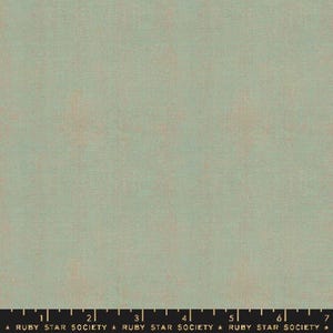 May include: A solid green fabric with a subtle texture. The fabric has a slightly faded look, giving it a vintage feel.