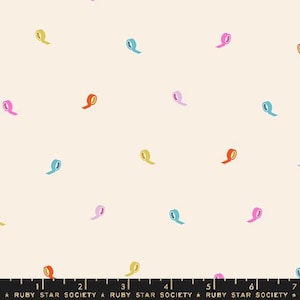 Pode incluir: Tecido creme com um padrão repetido de rolos de fita coloridos em amarelo, laranja, rosa e azul. O tecido tem um design lúdico e caprichoso, adequado para vários projetos de artesanato. O texto "RUBY STAR SOCIETY" está na parte inferior.