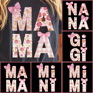 May include: A dark gray t-shirt with the word "MAMA" in large, decorative letters. The letters are adorned with pink bows and fall-themed patterns of pumpkins and leaves. Additional images show "NANA", "GiGi", "MiMi", and "MiNi" designs.