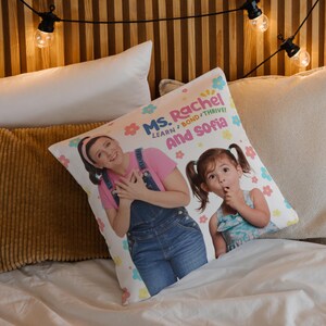 May include: A white pillow with a colorful design featuring two women. The text on the pillow reads "Ms. Rachel Learn, Bond, Thrive! And Sofia".