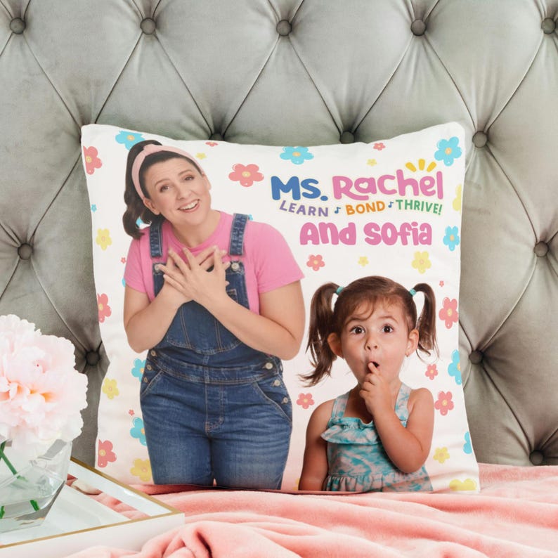 May include: A white pillow with a colorful floral pattern. The pillow features a photo of a woman and a young girl. The text on the pillow reads "Ms. Rachel Learn + Bond + Thrive! And Sofia".