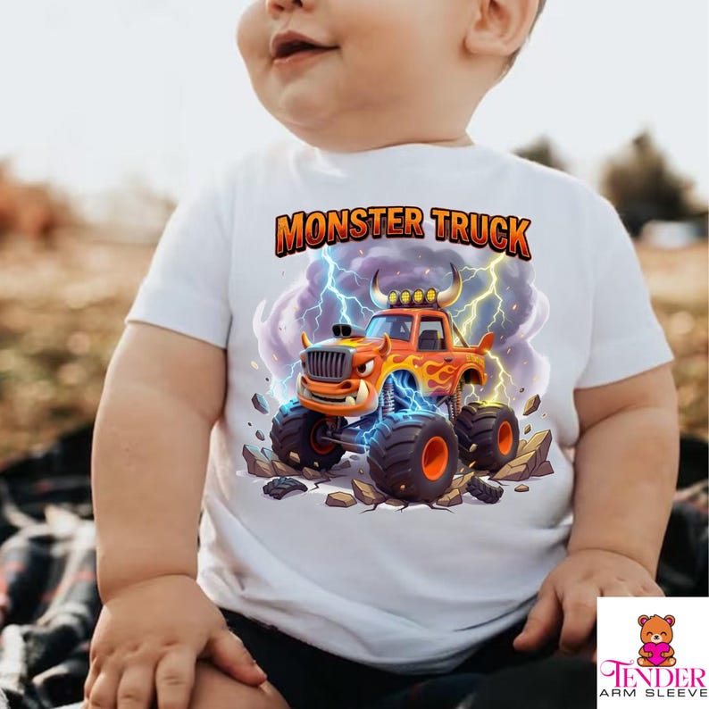 Puede incluir: Camiseta blanca de manga corta con un dise&ntilde;o de cami&oacute;n monstruo de dibujos animados. El cami&oacute;n naranja tiene llamas, neum&aacute;ticos grandes y el texto "MONSTER TRUCK" encima. El dise&ntilde;o incluye rayos y un fondo rocoso.
