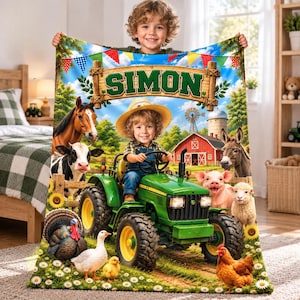 Puede incluir: Una manta de forro polar personalizada que muestra a un niño con sombrero de paja conduciendo un tractor verde en una granja. La escena incluye un granero rojo, un molino y animales como caballo, vaca, burro, cerdo, oveja, pavo y gallina. El nombre SIMON aparece en un letrero de madera.