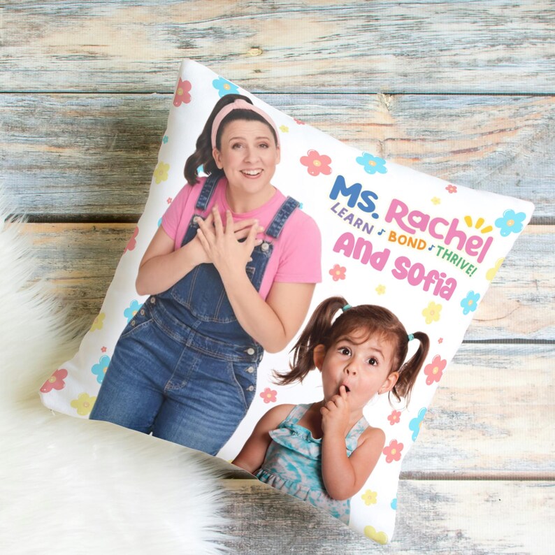 May include: White throw pillow with a colorful floral pattern. The pillow features a photo of a woman and a young girl with the text "Ms. Rachel Learn, Bond, Thrive! And Sofia" printed on the pillow.