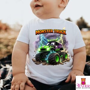 May include: White t-shirt featuring a vibrant monster truck design. The graphic includes a green and black monster truck with lightning bolts and the words "MONSTER TRUCK" in orange. The truck has large tires and a skull design.