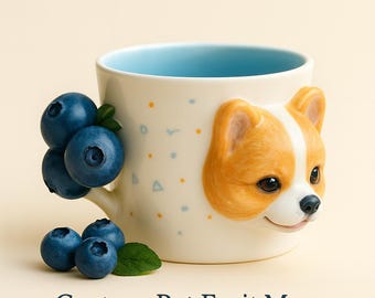Może przedstawiać: Kremowy ceramiczny kubek z jasnoniebieskim wnętrzem i trójwymiarową twarzą psa corgi z boku. Kubek jest ozdobiony niebieskimi i pomarańczowymi kropkami i trójkątami. Jagody są przymocowane do uchwytu. Tekst "Custom Pet Fruit Mug" znajduje się na dole.