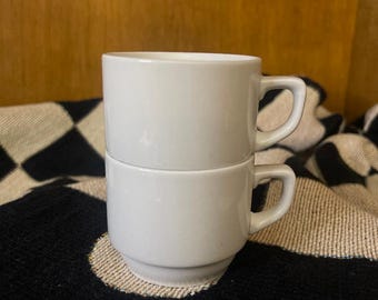 Par de tazas pequeñas blancas apilables para espresso