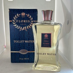 Peut inclure: Une boîte bleue et dorée avec le texte "Floris London" et "Toilet Water" dessus. La boîte contient un flacon en verre transparent d'eau de toilette "Limes Floris" avec un bouchon doré. Le flacon est de 7 fl. oz. ou 200 ml.