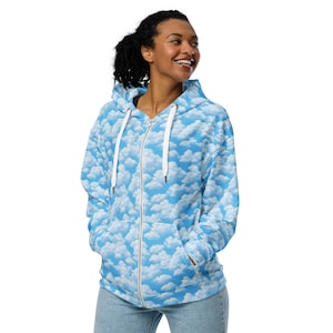 May include: A blue zip-up hoodie with a white cloud pattern. The hoodie has a hood with a drawstring and two pockets.