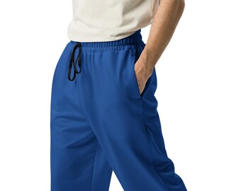 May include: Royal blue sweatpants with a black drawstring and pockets. The pants are made of a smooth fabric and have a relaxed fit. The model is wearing a cream-colored t-shirt.