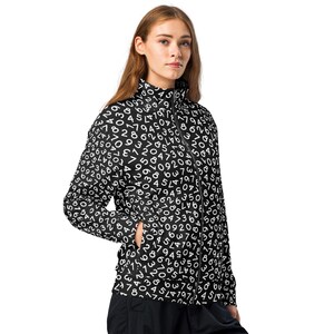 May include: A black and white zip-up jacket with a high collar. The jacket is covered in a repeating pattern of white numbers on a black background. The jacket has a black zipper and a pocket on the left side.