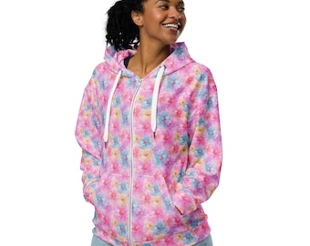 May include: A pink zip-up hoodie with a floral print featuring pink, blue, and yellow flowers. The hoodie has a white zipper and white drawstrings.