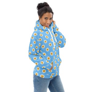 May include: A light blue hoodie with a white drawstring and a pattern of yellow smiling suns.