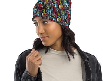 May include: A colorful beanie with a vibrant, abstract pattern in red, blue, yellow, and black. The beanie is worn by a person wearing a black denim jacket and a white t-shirt.