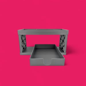 May include: A gray plastic desk organizer with two tiers. The top tier is open and the bottom tier is a drawer. The drawer is pulled out and the organizer is sitting on a pink surface.