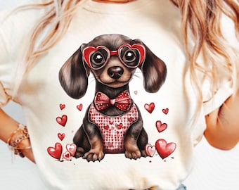 Puede incluir: Una camiseta blanca con una imagen de dibujos animados de un dachshund con gafas de corazón rojo y una pajarita roja. El dachshund está rodeado de corazones rojos.