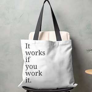 May include: White tote bag with black handles and the text "It works if you work it." printed on the front.