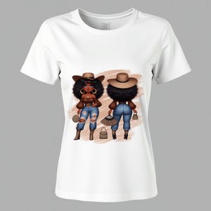 May include: White t-shirt featuring a cartoon illustration of two women. The women are depicted with brown skin, curly black hair, and wearing brown hats, tops, ripped blue jeans, and boots. They are also holding purses and fans.