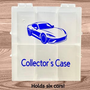 May include: Clear plastic collector's case with six compartments. A blue sports car graphic is on the front, with the words "Collector's Case" below. The text "Holds six cars!" is at the bottom.