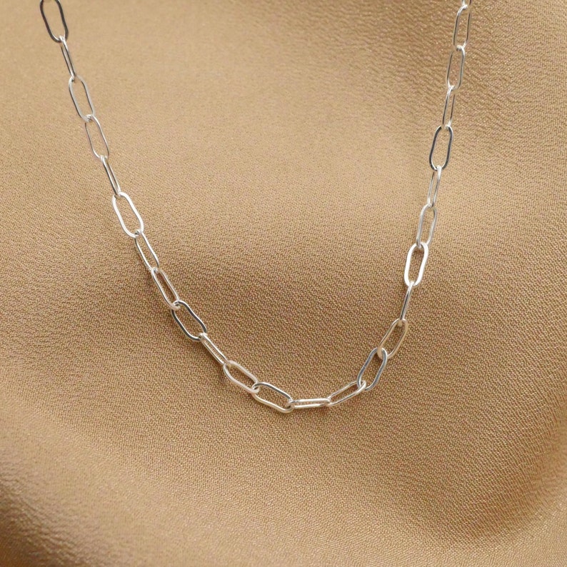 May include: A silver chain necklace with oval links.