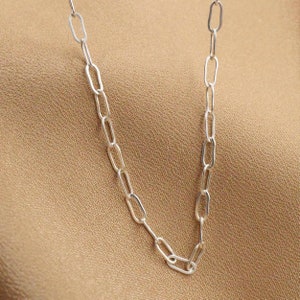 May include: A silver chain necklace with oval links.
