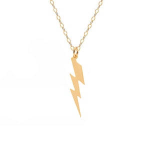 May include: A gold chain necklace with a lightning bolt pendant.