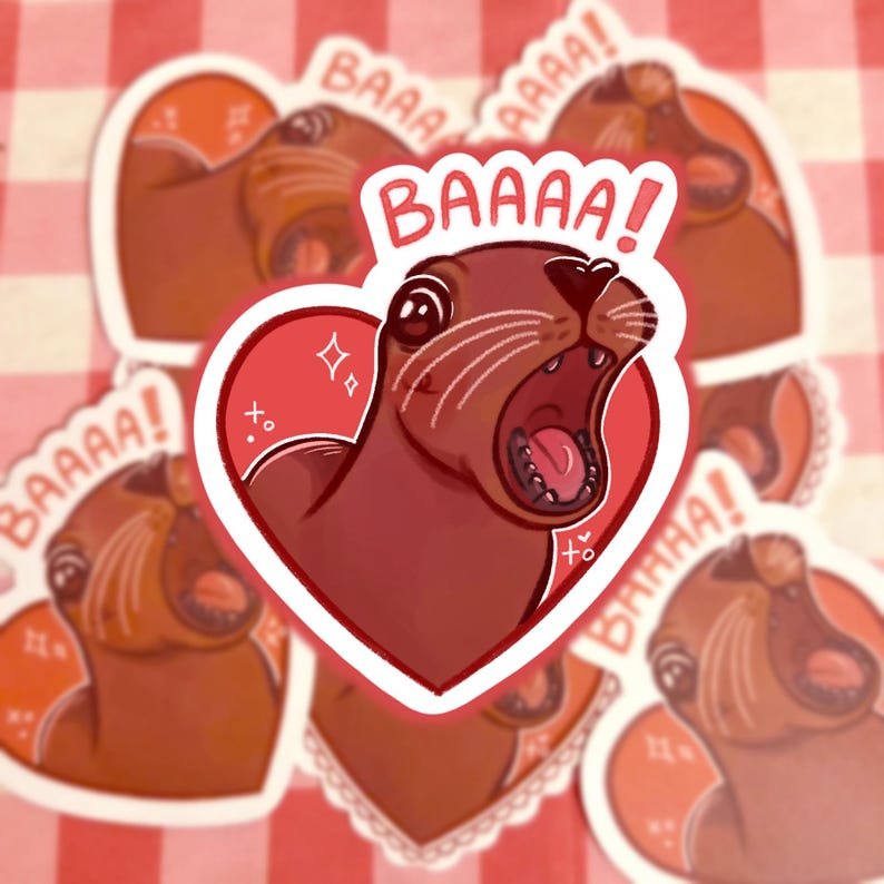 May include: A sticker featuring a cartoon sea otter with an open mouth inside a red heart. The sea otter is brown with white whiskers and the word "BAAAA!" is written above it. Additional stickers with the same design are in the background.