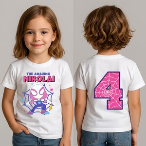 Puede incluir: Camiseta blanca con un personaje de dibujos animados y el texto "THE AMAZING NIKOLAI" en rosa y azul. La parte trasera de la camiseta muestra un gran n&uacute;mero 4 rosa con un dise&ntilde;o de telara&ntilde;a, contorneado en azul.