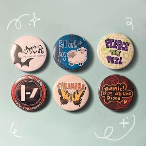 May include: Six round buttons with band logos and graphics. The buttons feature text and images from bands like My Chemical Romance, Fall Out Boy, Paramore, and Panic! at the Disco. The buttons are on a light blue background.