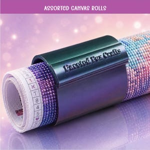 Puede incluir: Un lienzo de pintura de diamantes enrollado, asegurado con un clip de plástico verde oscuro que presenta el texto en relieve Faceted Fox Crafts. El lienzo muestra una cuadrícula de cuentas coloridas y un margen blanco con símbolos y números.