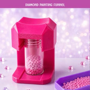 May include: A bright pink diamond painting funnel stand holding a clear glass jar filled with small pink beads. The text DIAMOND PAINTING FUNNEL is printed at the top. A purple tray containing more pink beads is positioned to the right.