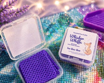 May include: Open clear plastic containers holding purple anti-static sheets. One container is open, revealing the sheets. Another container displays the text "Whisker Whiffs" and "Sea Glass Glow". The image is of a crafting product.
