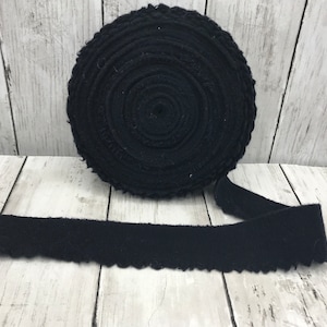 Peut inclure: Un rouleau de galon en coton noir avec un bord festonn&eacute;. Le galon est enroul&eacute; et nou&eacute; avec un ruban.