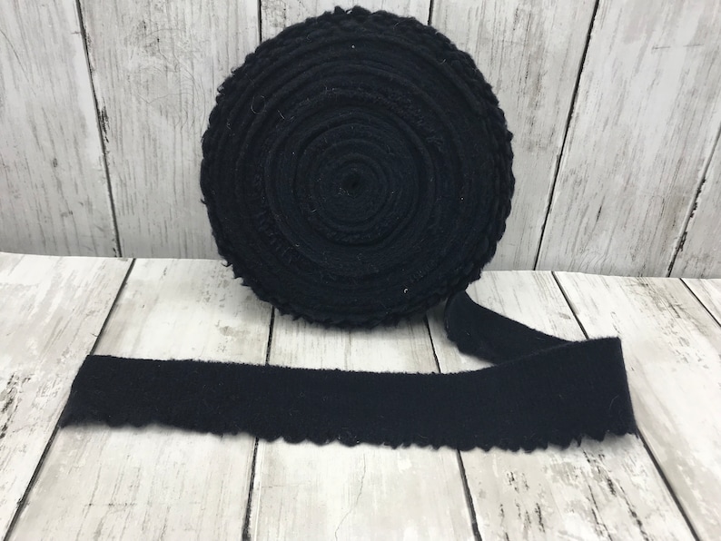 Peut inclure: Un rouleau de galon en coton noir avec un bord festonn&eacute;. Le galon est enroul&eacute; et nou&eacute; avec un ruban.
