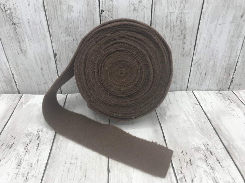Peut inclure: Un rouleau de tissu en feutre brun. Le feutre est enroul&eacute; et attach&eacute; avec une ficelle brune. Le feutre mesure environ 2,5 cm de large.