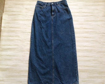 May include: A long, dark blue denim skirt. The skirt has a classic five-pocket design, a button and zipper closure, and a straight silhouette. The skirt is made of a sturdy denim fabric and appears to be in good condition.