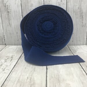Peut inclure: Un rouleau de ruban en tissu bleu fonc&eacute;. Le ruban est enroul&eacute; et l'extr&eacute;mit&eacute; est d&eacute;roul&eacute;e.