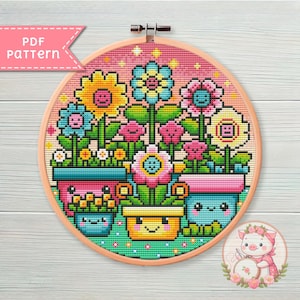 Op de afbeelding: Borduurpatroon van een kleurrijk bloemstuk in potten met vrolijke gezichten. De bloemen zijn roze, geel, blauw en groen. De potten zijn roze, blauw en geel. De achtergrond is lichtroze met witte sterren.