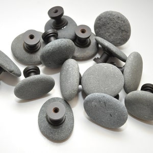 Peut inclure: Un ensemble de boutons de porte en pierre grise avec des ferrures en m&eacute;tal noir. Les boutons sont de forme ovale et ont une texture rugueuse et naturelle.