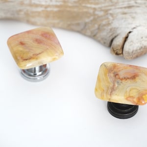 May include: Two square agate cabinet knobs with a natural stone pattern in shades of yellow, orange, and brown. One knob has a chrome base and the other has a black base.