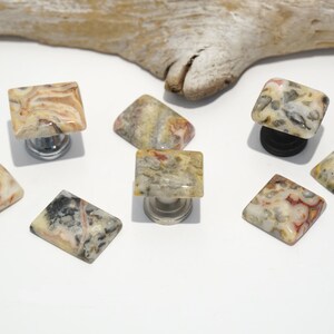 May include: Assortment of agate stone cabinet knobs in various shades of brown, white, and gray with natural patterns. The knobs are square and rectangular in shape and have a polished finish.